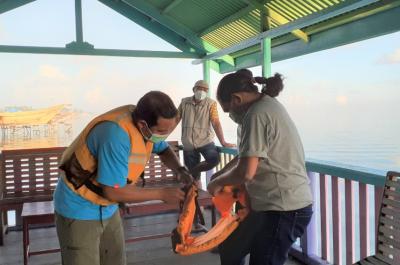 Safety comes first, putting on the life jacket before getting on the speedboat